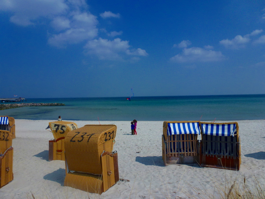 Blick über Strandkörbe auf Wasser